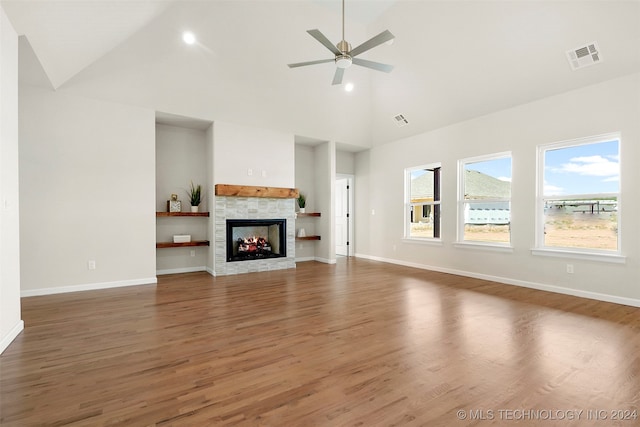 unfurnished living room featuring ceiling fan, a fireplace, dark hardwood / wood-style floors, and high vaulted ceiling