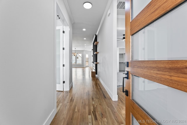 hall featuring light wood-type flooring and crown molding