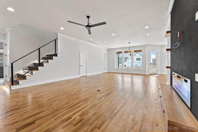 unfurnished living room featuring ceiling fan, crown molding, and light hardwood / wood-style floors