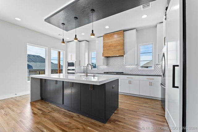 kitchen with pendant lighting, white cabinets, a wealth of natural light, and a spacious island