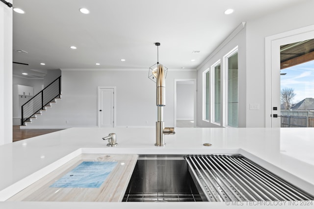 kitchen featuring wood-type flooring, decorative light fixtures, and ornamental molding