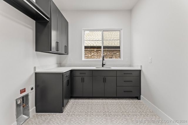 laundry area with cabinets and sink