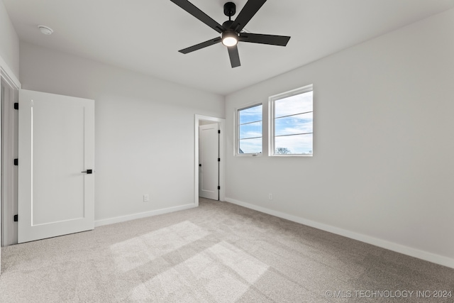 unfurnished bedroom with ceiling fan and light colored carpet