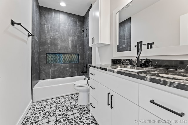 full bathroom featuring tiled shower / bath, vanity, tile patterned flooring, and toilet