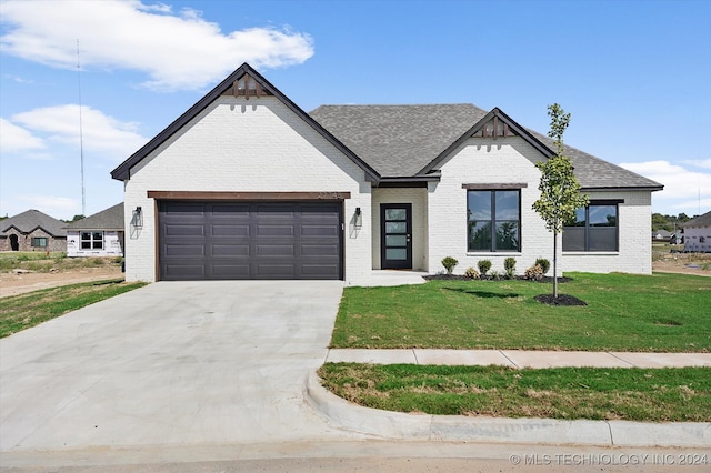 view of front of home featuring a garage and a front lawn