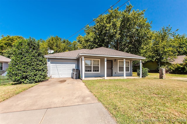 view of front of house featuring a garage, a front lawn, and covered porch