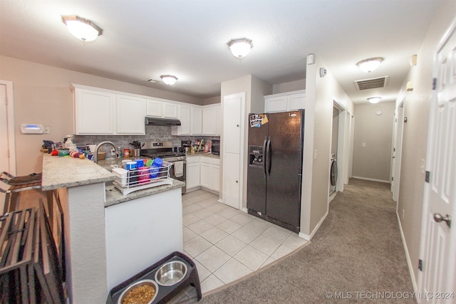 kitchen with black fridge, white cabinets, kitchen peninsula, tasteful backsplash, and stainless steel stove