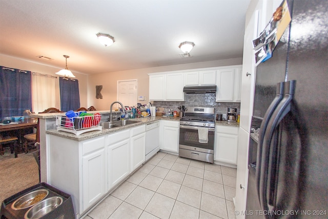 kitchen with gas stove, black fridge, kitchen peninsula, decorative light fixtures, and white dishwasher