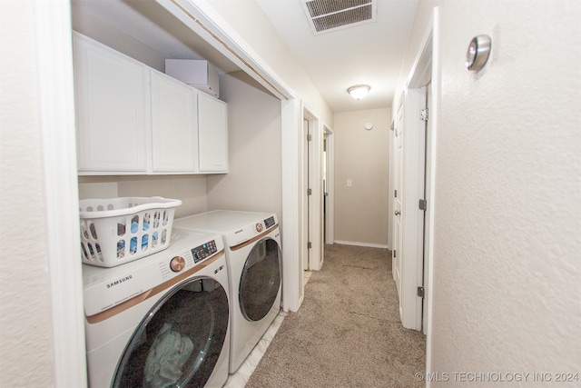 washroom featuring cabinets and independent washer and dryer