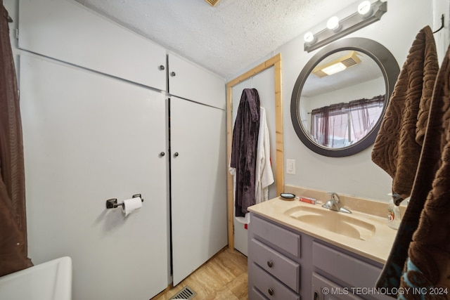 bathroom featuring a textured ceiling and vanity