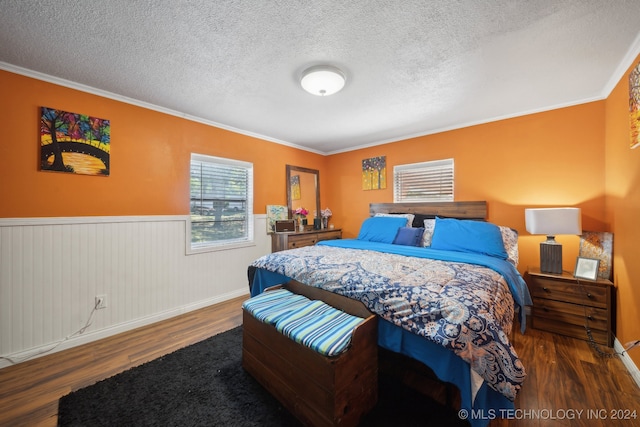 bedroom featuring a textured ceiling, wooden walls, crown molding, and dark hardwood / wood-style flooring