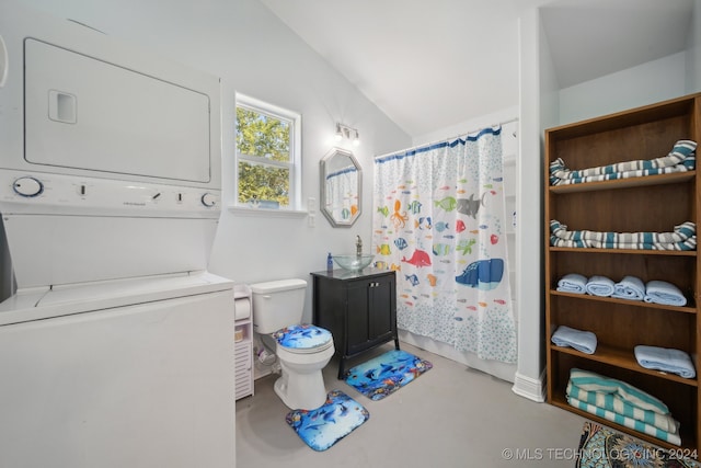 bathroom featuring vaulted ceiling, vanity, stacked washer and dryer, concrete flooring, and toilet