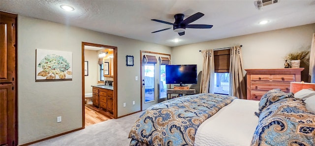 carpeted bedroom featuring ceiling fan, access to exterior, a textured ceiling, and ensuite bath