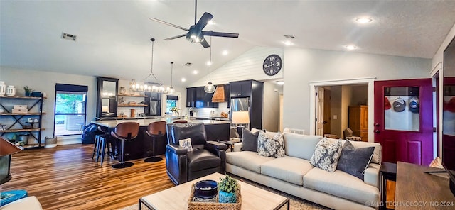 living room with dark hardwood / wood-style flooring, high vaulted ceiling, and ceiling fan with notable chandelier