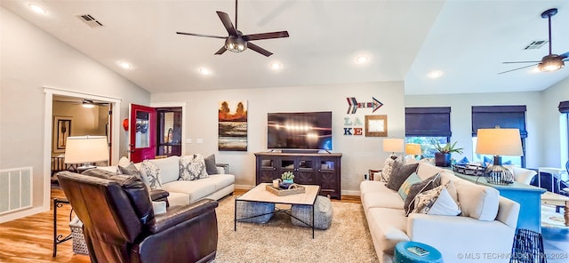 living room with light hardwood / wood-style flooring and vaulted ceiling