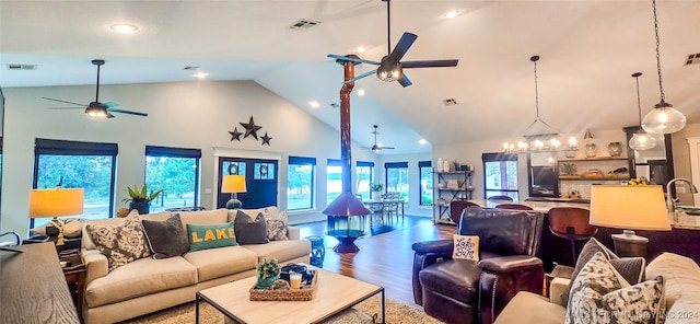 living room featuring hardwood / wood-style floors, high vaulted ceiling, and a notable chandelier