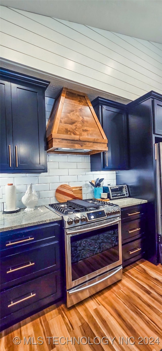 kitchen featuring blue cabinetry, stainless steel appliances, and custom exhaust hood