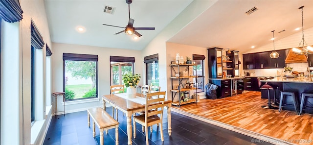 dining space featuring dark hardwood / wood-style floors, high vaulted ceiling, and ceiling fan