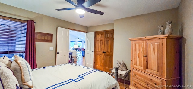 bedroom featuring multiple windows, wood-type flooring, a closet, and ceiling fan