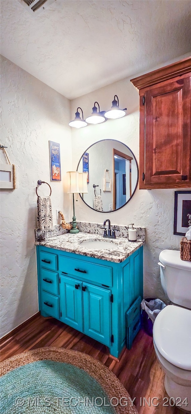 bathroom featuring hardwood / wood-style floors, vanity, and toilet