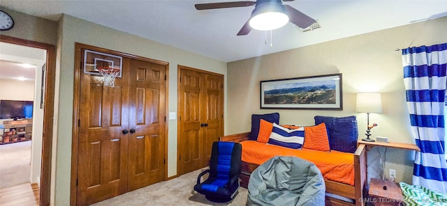 living area with ceiling fan and carpet floors