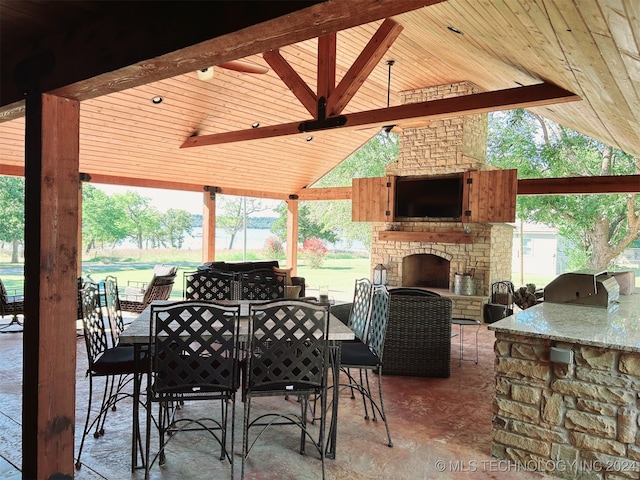 view of patio / terrace with an outdoor stone fireplace, area for grilling, a gazebo, and a grill