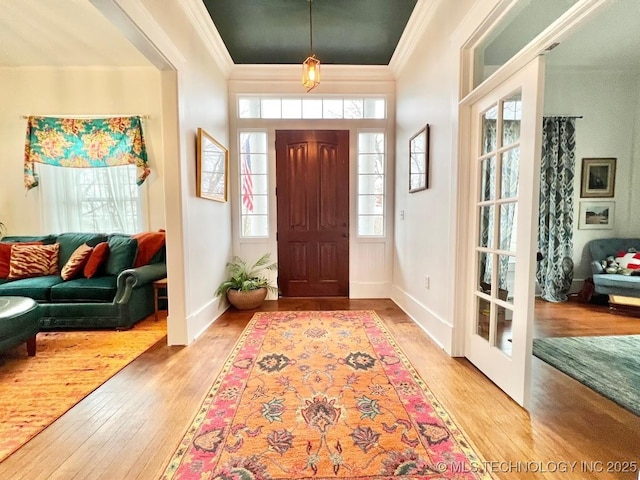 entryway featuring crown molding and light hardwood / wood-style flooring