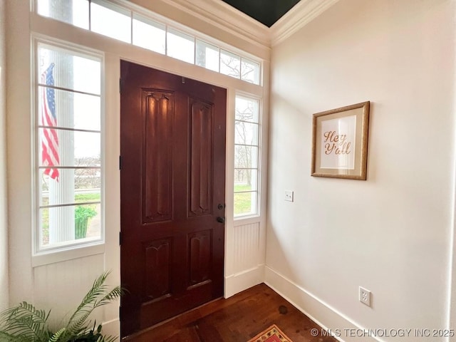 foyer entrance with crown molding and dark hardwood / wood-style flooring