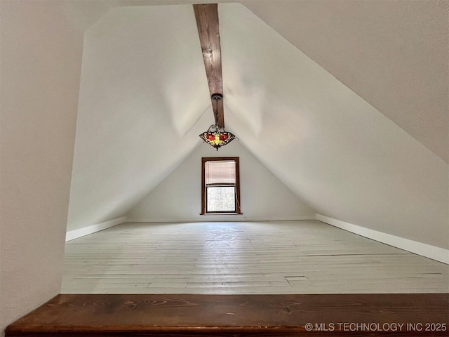 additional living space with wood-type flooring and lofted ceiling