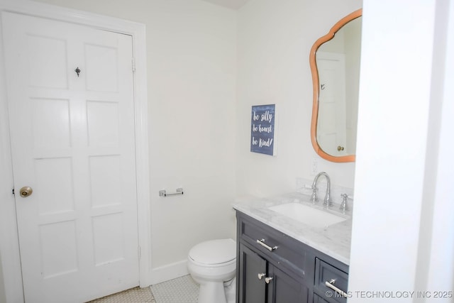 bathroom with tile patterned flooring, vanity, and toilet