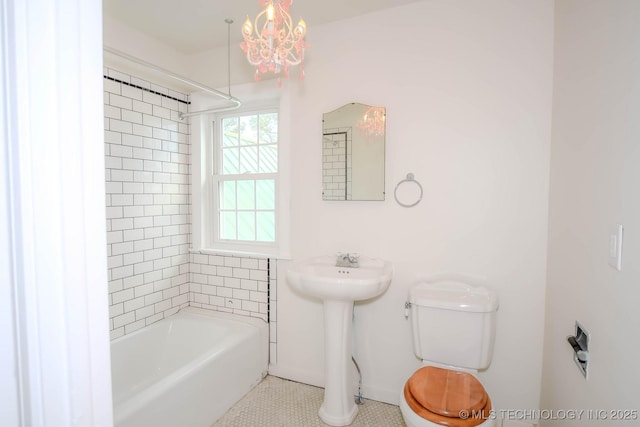 bathroom with tile patterned flooring, toilet, and tiled shower / bath