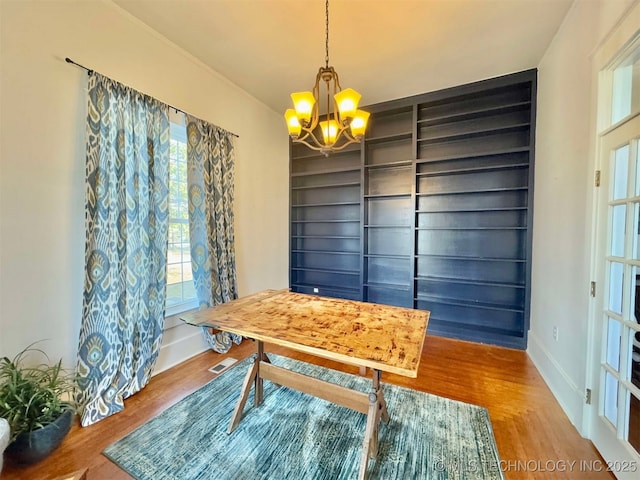 dining space featuring hardwood / wood-style flooring and a chandelier