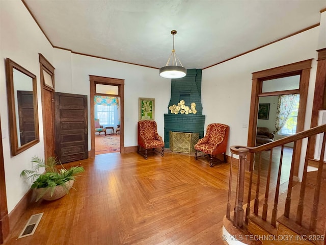 living area with parquet flooring and ornamental molding