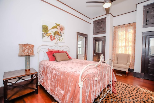 bedroom featuring hardwood / wood-style flooring, ceiling fan, and ornamental molding