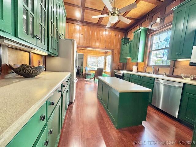 kitchen featuring stainless steel appliances, coffered ceiling, green cabinets, plenty of natural light, and a kitchen island