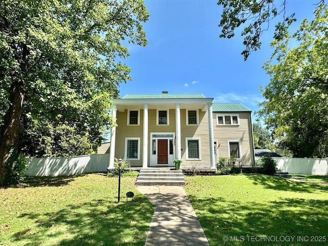 neoclassical home featuring a front yard