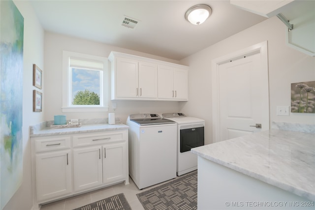 clothes washing area with cabinets, independent washer and dryer, and light tile patterned flooring