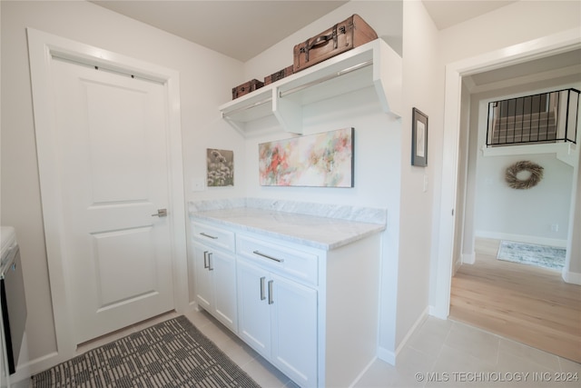 kitchen with light hardwood / wood-style flooring, light stone counters, and white cabinets