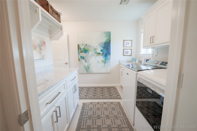 washroom with cabinets, tile patterned floors, and separate washer and dryer