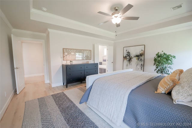 bedroom featuring light wood-type flooring, crown molding, ceiling fan, and a raised ceiling