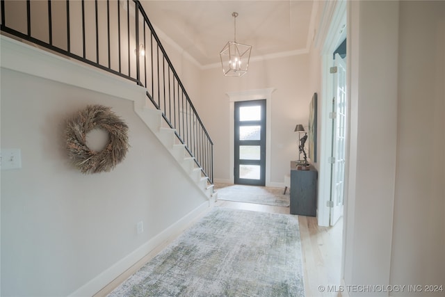 foyer entrance featuring an inviting chandelier, crown molding, and light hardwood / wood-style floors