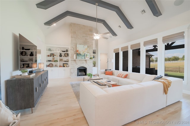 living room featuring ceiling fan, beam ceiling, a stone fireplace, high vaulted ceiling, and light wood-type flooring