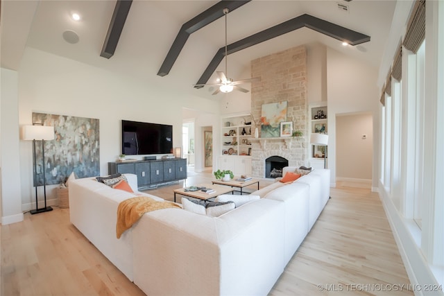 living room with light hardwood / wood-style floors, beam ceiling, a fireplace, high vaulted ceiling, and ceiling fan