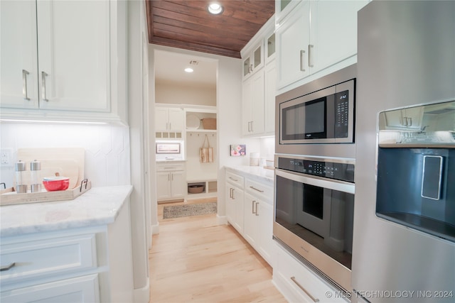 kitchen featuring wood ceiling, white cabinetry, light stone counters, stainless steel appliances, and light hardwood / wood-style flooring