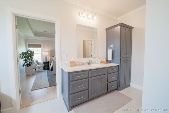 bathroom featuring ornamental molding, hardwood / wood-style flooring, and vanity