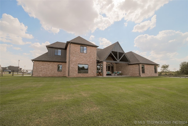 rear view of property with a patio and a yard