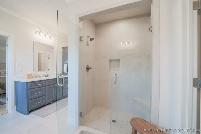 bathroom featuring vanity, ornamental molding, a shower with door, and tile patterned floors