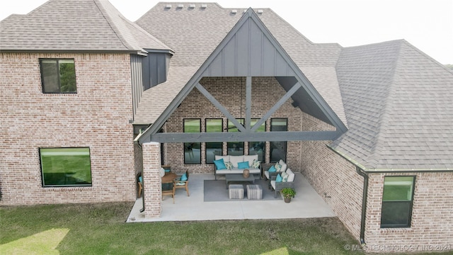 back of property with a patio, a yard, and an outdoor living space