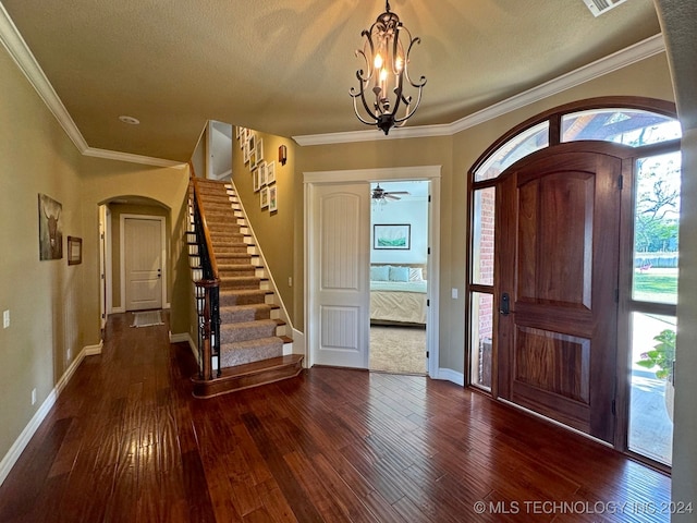 entrance foyer featuring a textured ceiling, ceiling fan with notable chandelier, crown molding, and dark hardwood / wood-style flooring