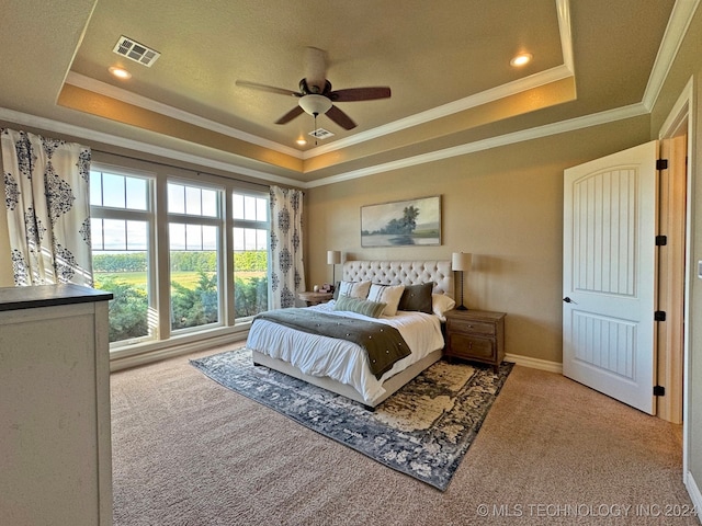 carpeted bedroom featuring ceiling fan, a raised ceiling, and crown molding